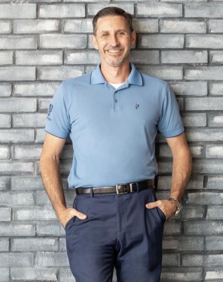 Sean Kramer standing against a painted brick wall